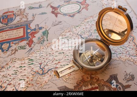 An old brass compass lying on an ancient map of Cornwall - John Gollop Stock Photo