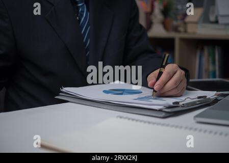 Businessman analyzing business planning, strategy, marketing and financial reports Hand Holding File, Checking reports, and reviewing business statist Stock Photo