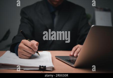 man hands with pen writing on notebook in the office.learning, education and work.writes goals, plans, make to do and wish list on desk. Stock Photo