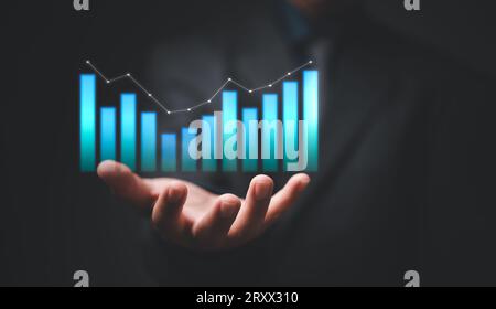Hand showing graph and chart virtual hologram of statistics with arrow up on virtual interface. Digital marketing. Planning and strategy development S Stock Photo