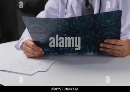 Doctor holding x-ray film before surgery. MRI and CT scan examining at diagnosing patient’s health with radiological for medical healthcare Stock Photo