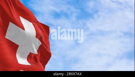 Switzerland national flag waving in the wind on a clear day. Red background with a white cross in the center. 3d illustration render. Fluttering fabri Stock Photo