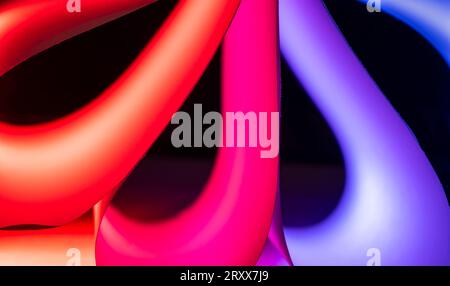 Closeup of red & blue colored curving shapes made for ordinary white sheets of paper and colored lights Stock Photo