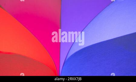 Closeup of red & blue colored curving shapes made for ordinary white sheets of paper and colored lights Stock Photo