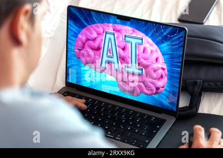27 September 2023: Artificial intelligence on a laptop computer, man in front of screen with a digital space and a brain with the letters AI FOTOMONTAGE *** Künstliche Intelligenz auf einem Laptop Computer, Mann vor Bildschirm mit einem digitalen Raum und einem Gehirn mit den Buchstaben AI FOTOMONTAGE Stock Photo