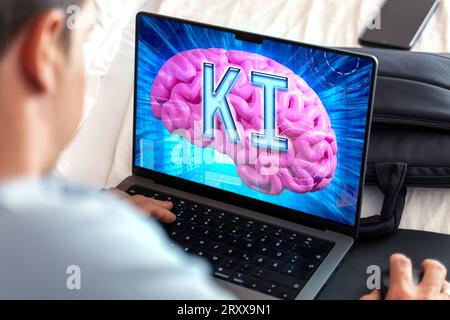 27 September 2023: Artificial intelligence on a laptop computer, man in front of screen with a digital space and a brain with the letters AI PHOTOMONTAGE *** Künstliche Intelligenz auf einem Laptop Computer, Mann vor Bildschirm mit einem digitalen Raum und einem Gehirn mit den Buchstaben KI FOTOMONTAGE Stock Photo