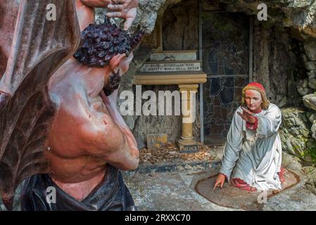 Sculpture of the devil and St Anthony of Padua at grotto in the village Crupet, Assesse, province of Namur, Belgian Ardennes, Wallonia, Belgium Stock Photo