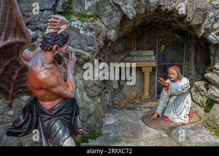 Sculpture of the devil and St Anthony of Padua at grotto in the village Crupet, Assesse, province of Namur, Belgian Ardennes, Wallonia, Belgium Stock Photo