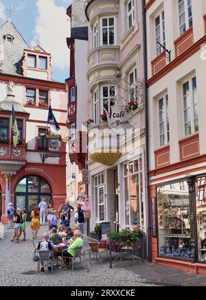 Tourists in the old town square of medieval Bernkastel-Kues located on the banks of the Moselle River in Germany. People sitting enjoying cake and cof Stock Photo