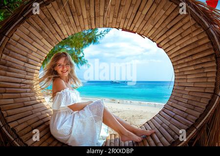 Vacationing woman in white dress enjoying the tranquil ocean view Stock Photo