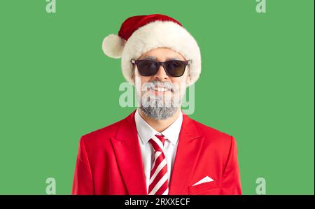 Portrait of a handsome young man in sunglasses and Santa Claus hat. Stock Photo