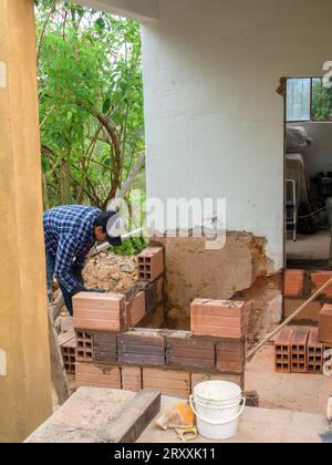 A man building a little room with hollow bricks in a farmhouse near the town of Arcabuco in the eastern Andean mountains of central Colombia. Stock Photo