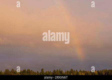 Beautiful view of stormy sky with rainbow during rain. Stock Photo