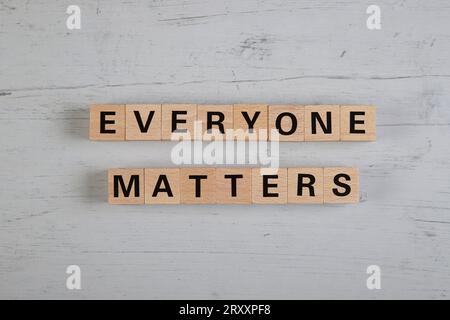 wooden blocks  in a white and grey board with the text everyone matters Stock Photo