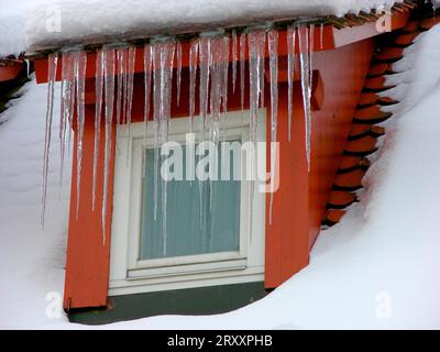 Window with long icicles on the roof Snow Stock Photo
