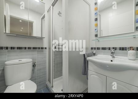 Small bathroom with white wooden furniture, porcelain sink Stock Photo