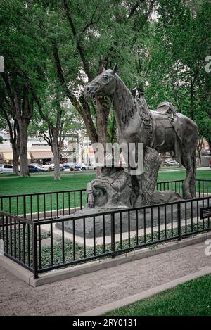 'Cowboy at Rest' bronze statue on the grounds of the Yapavapi county courthouse plaza depicts pensive cowboy resting with his steed, Prescott, AZ Stock Photo