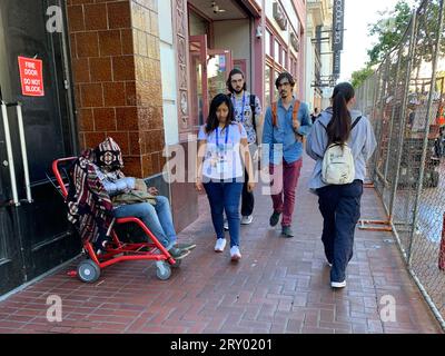 August 16, 2023, San Francisco, California, USA: Homeless man outside of retail shops as convention goers pass by on Market Street in San Francisco, California on Wednesday August 16, 2023. Many retailers are citing homeless problems and other challenges of operating in Downtown San Francisco and contemplating whether to remain open. (Credit Image: © David G. McIntyre/ZUMA Press Wire) EDITORIAL USAGE ONLY! Not for Commercial USAGE! Stock Photo