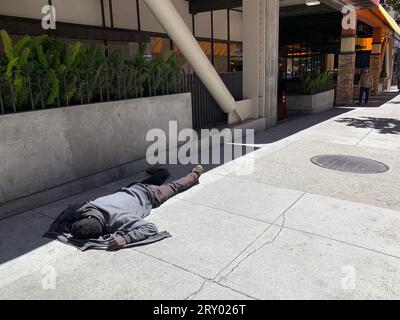 August 16, 2023, San Francisco, California, USA: A homeless man sleeps on the sidewalk by the former location of Office Max off of Market Street in San Francisco, California on Wednesday August 16, 2023. Many retailers are citing homeless problems and other challenges of operating in Downtown San Francisco and contemplating whether to remain open. (Credit Image: © David G. McIntyre/ZUMA Press Wire) EDITORIAL USAGE ONLY! Not for Commercial USAGE! Stock Photo