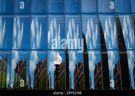 Reflections of clouds and buildings on the glass facade of an office building in downtown Washington DC USA Stock Photo