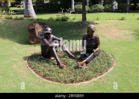 Bronze sculptures of the owners and creator of Na Aina Kai Botanical Gardens sitting on the ground, named 'The Beginning' in Na Aina Kai Botanical Gar Stock Photo