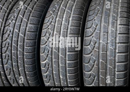 Closeup of rough huge winter tires designed with ornamental pattern and textured to suit frost and snow terrain while stacked together in full frame i Stock Photo