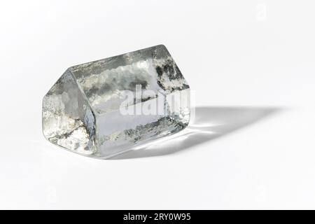 Translucent house made of whole piece of fragile glass casting shadow on white background Stock Photo