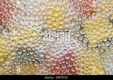 Water drops on glass surface with colorful background Stock Photo