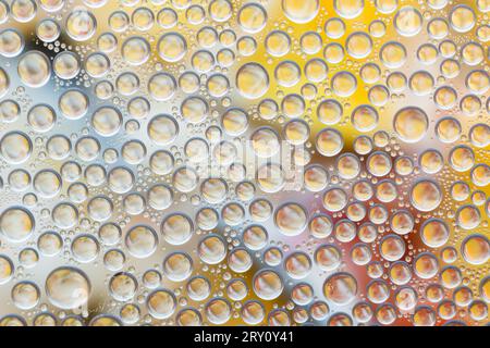 Water drops on glass surface with colorful background Stock Photo