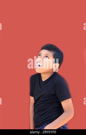 9-year-old dark-skinned Latino boy wearing vampire costume teeth to play and trick-or-treat on Halloween Stock Photo