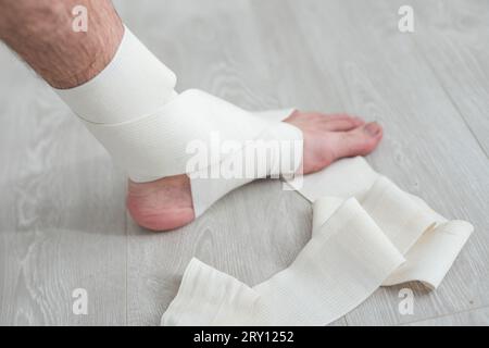 man using put on elastic bandage with legs having leg pain Stock Photo