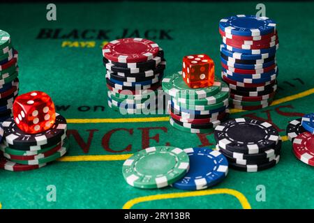 Stack of green, red, blue, white and black Playing Poker Chips in a green background Stock Photo