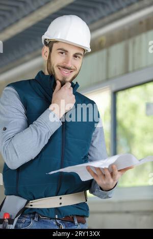happy man builder holding drawing Stock Photo