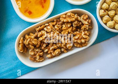 Pile of walnuts in a white porcelain bowl on the breakfast table Stock Photo