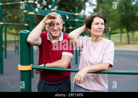 Elderly man and woman posing in open-air sports bars complex Stock Photo