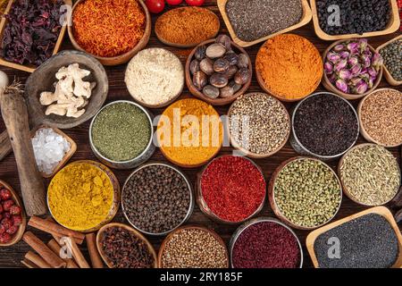 Colorful background with various herbs and spices for cooking in bowls. Seamless texture with spices and herbs. Stock Photo