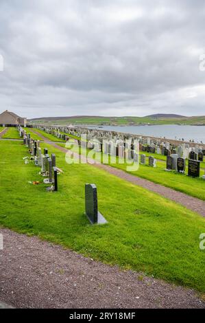 Graveyard Cemetery on Shetland Island on a hill with sea in the background during cloudy day, vertical shot Stock Photo