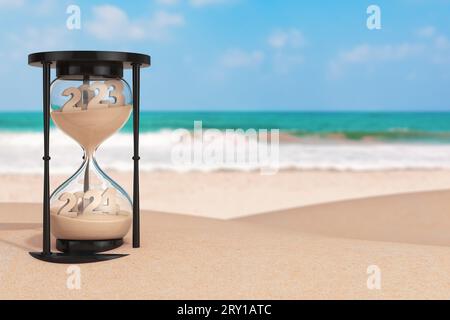 2024 New Year Vacation Concept.  Sand Falling in Hourglass Taking the Shape from 2023 to 2024 year on an Ocean Deserted Coast extreme closeup. 3d Rend Stock Photo