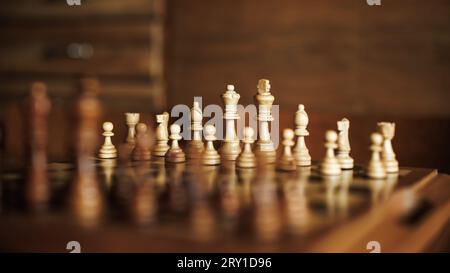 Wooden chess board with set of chess pieces on table. Leisure games. Selective focus Stock Photo
