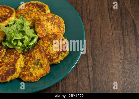 Oatmeal fritters with vegetables served on a plate on a wooden table. Healthy food. Stock Photo