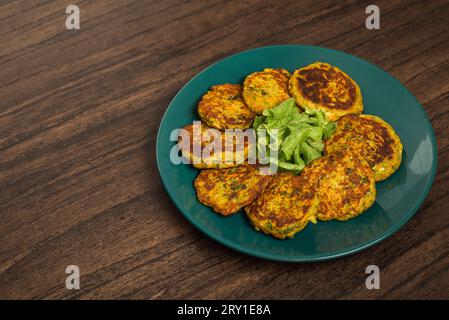 Oatmeal fritters with vegetables served on a plate on a wooden table. Healthy food. Stock Photo
