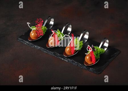 Molecular modern cuisine galantine duck in spoons on stone and rusty background. Top view. Stock Photo