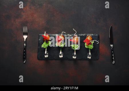 Molecular modern cuisine galantine duck in spoons on stone and rusty background. Top view. Stock Photo