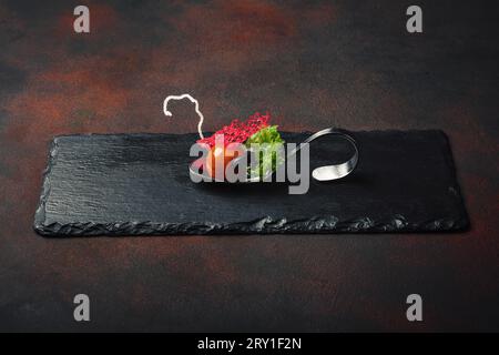 Molecular modern cuisine galantine duck in spoons on stone and rusty background. Top view. Stock Photo