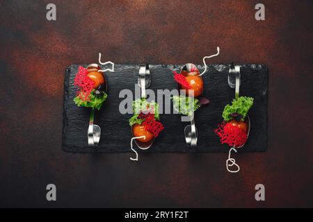 Molecular modern cuisine galantine duck in spoons on stone and rusty background. Top view. Stock Photo