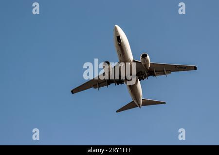 Underneath a WestJet airlines C-GWCM Boeing 737-700 a Canadian low- cost airline plane jet flying into Vancouver International Airport (YVR) Stock Photo