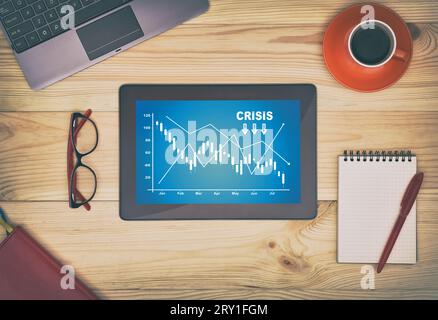 Business chart showing financial crisis at stock market on screen tablet. Business and failure chart concept. Stock Photo
