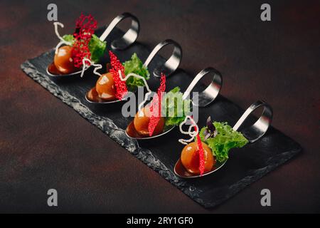 Molecular modern cuisine galantine duck in spoons on stone and rusty background. Top view. Stock Photo