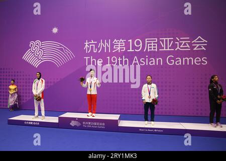 HANGZHOU, CHINA - SEPTEMBER 28, 2023 - Li Yueyao of China poses on the winner's podium during the women's 52kg Martial Arts Kick-boxing competition at Stock Photo