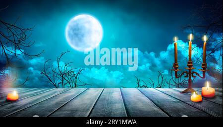 Fog in dark forest, abstract Halloween background.  Smoke and mist on old wooden table with candles, defocused Halloween backdrop. Stock Photo